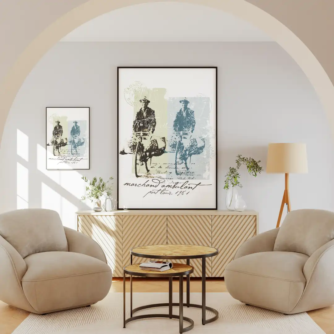 A cozy living room featuring two plush chairs, a wooden side table, and framed artwork depicting a bicycle courier.