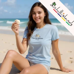 ChillIsland 'Hakuna Matata' T-shirt in Sky Blue, featured in a tropical lifestyle setting. This 100% Organic Cotton garment belongs to the ChillIsland 2025 Coastal Collection, showcasing the brand's signature relaxed fit and eco-friendly screen print.