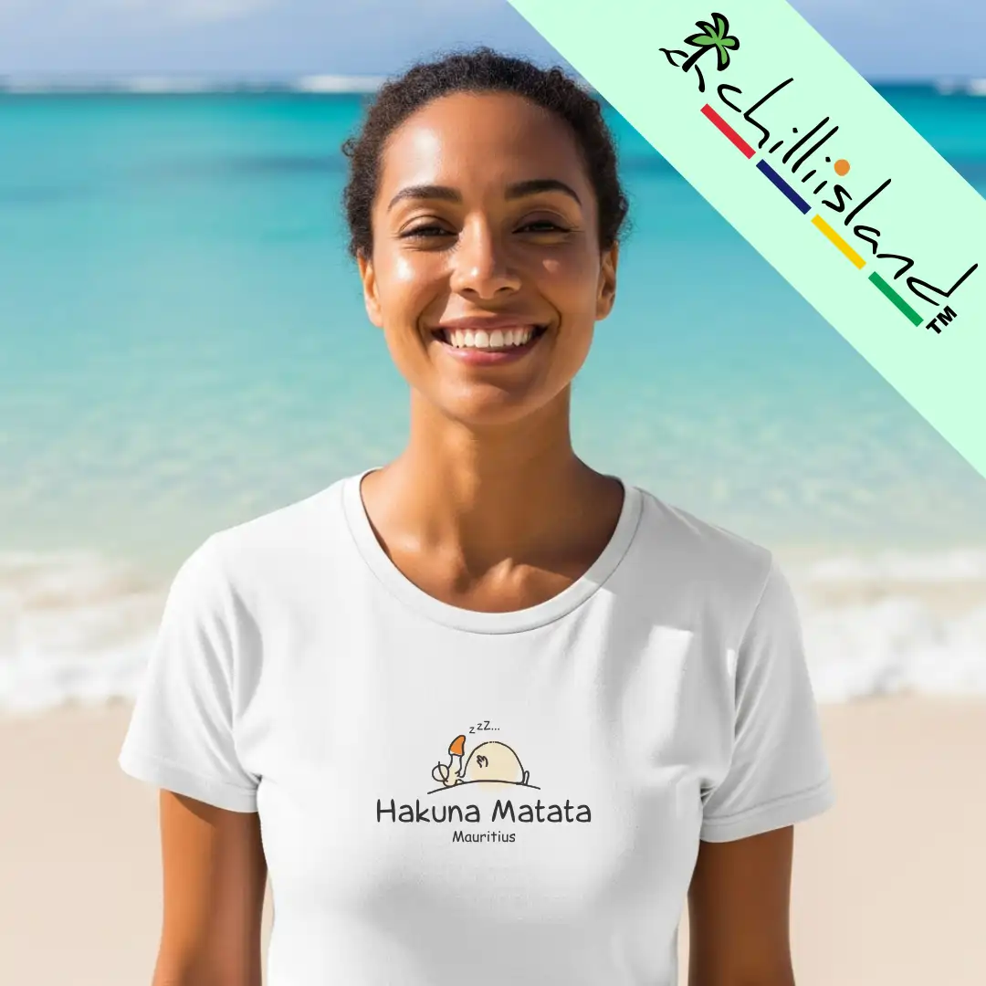Smiling woman in a white "Hakuna Matata, Mauritius" t-shirt, standing on a sunny beach with turquoise water. Chillisland logo in the top right corner.